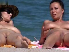 Mulheres nuas na praia sendo filmadas
